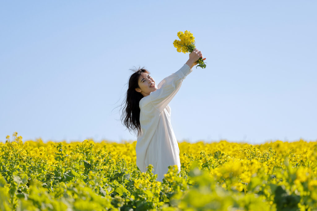 花畑で花束を持つ女性_野外のロケーション撮影イメージ